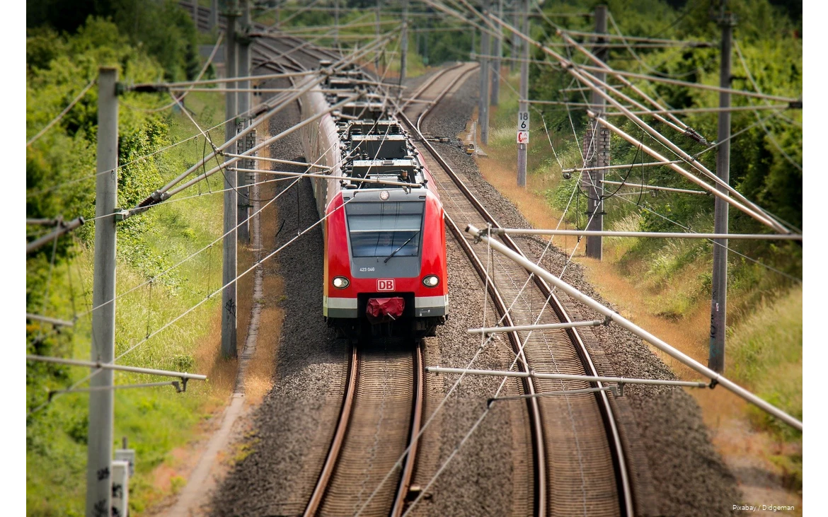 Ein Zug der Deutschen Bahn fährt durch die Landschaft.