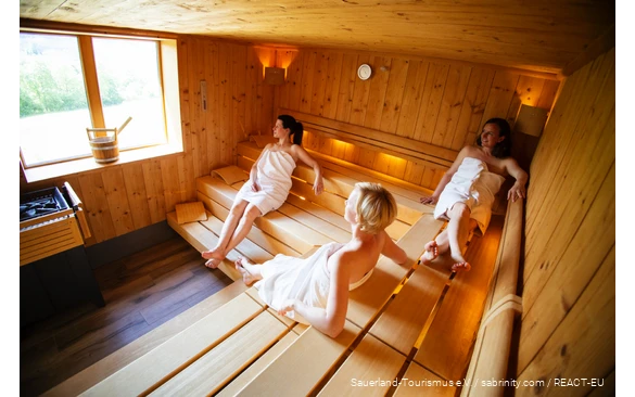 Drei Frauen entspannen in einer Sauna.
