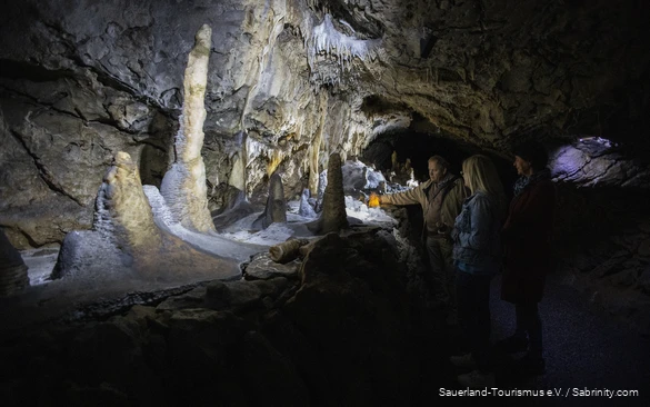 Der Höhlenführer bringt mit einer Taschenlampe einen Tropfstein zum leuchten.