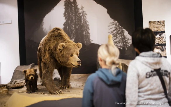 Zwei Frauen schauen sich im Höhlenmuseum zwei Bären an.