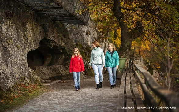 Eine Mutter kommt mit ihren beiden Töchtern aus der Bilsteinhöhle.