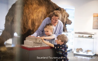 Eine Mutter erkundet mit ihren Kindern das Südsauerlandmuseum in Attendorn.