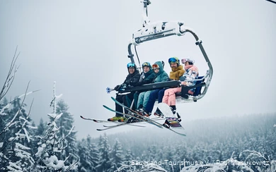Eine fröhliche Gruppe Wintersportler im Sessellift.
