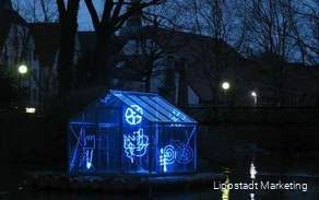 Ein Gewächshaus ist mit Lichtschläuchen in verschiedenen Formen beleuchtet.