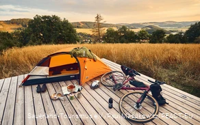 Gravelbike und Zelt auf einer Trekkingplattform mit Blick über die Landschaft des Sauerlandes